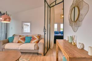 ein Wohnzimmer mit einem Sofa und einem Spiegel in der Unterkunft Truchet Penthouse in Arles
