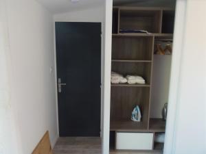 a closet with a black door and shelves at Joli Mazet entre Montpellier et Nimes in Aimargues