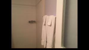 a bathroom with white towels hanging on a shower at Anna's Joye Seawind - Freeport, Montego Bay in Montego Bay