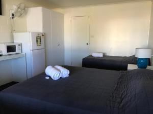 
a bedroom with a bed and a dresser at Porkys Motel in Rockhampton
