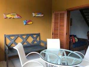uma sala de estar com uma mesa de vidro e um sofá em Vilage em Praia do Forte na Praia do Forte