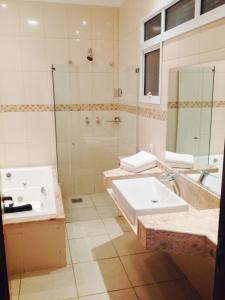 a bathroom with a sink and a shower and a tub at Habitat Hotel Pirassununga in Pirassununga