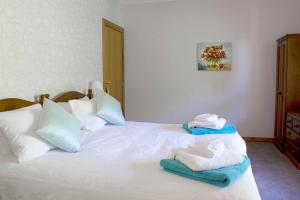 a bedroom with a white bed with towels on it at Bed & Breakfast at Tiffany's in McLaren Vale