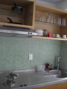 墨西哥城的住宿－Monoambientes Cuauhtemoc，厨房设有水槽和绿色瓷砖墙。