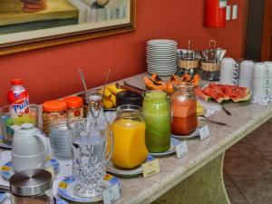 a table topped with drinks and plates of food at Hotel Portal da Lua in Iriri