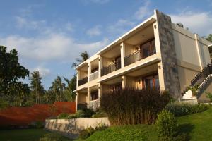 a large white building with trees in the background at Melasa House in Senggigi 