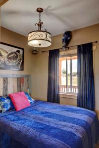 een slaapkamer met een blauw bed en een kroonluchter bij Mountain Haven Cabins in Mountain View +35 foto's