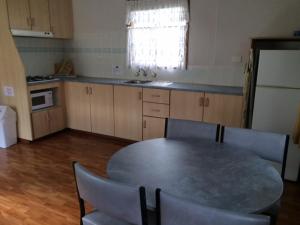 a kitchen with a table and chairs and a kitchen with a refrigerator at Smugglers Cove Holiday Village in Forster