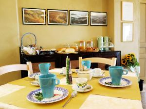 - une table à manger avec des tasses bleues et des assiettes dans l'établissement Ca Tupin, à Treiso