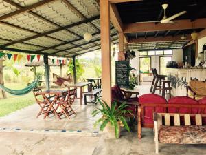 a patio with a table and chairs and a couch at Soluna Guest House in Pantai Cenang