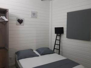 a bedroom with a bed and a flat screen tv at ChEZ MAYAH in Le Gosier