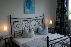 ein Schlafzimmer mit einem Bett mit Kissen und zwei Lampen in der Unterkunft Apartment-Hotel Rackwitz in Rackwitz