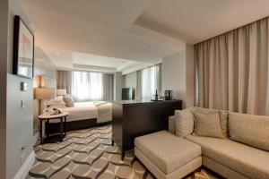 a hotel room with a bed and a couch at Mayfair Hotel in Adelaide