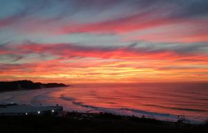 a sunset over the ocean with a red at The Paralian Exclusive Guest House in East London