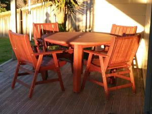 a wooden table and chairs on a deck at Ohope Lifestyles in Ohope Beach
