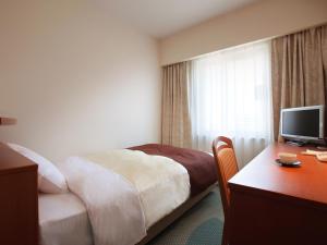 
a hotel room with two beds and a television at Hotel Pearl City Morioka in Morioka
