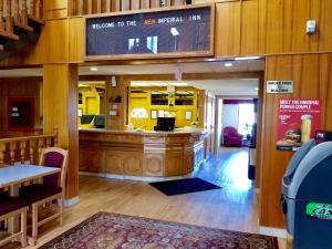 a restaurant with a counter in the middle of a room at New Imperial Inn in Cold Lake