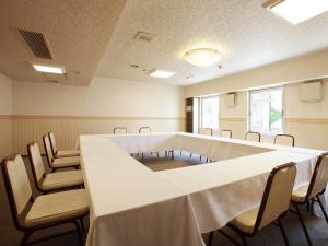 uma sala de conferências com uma mesa longa e cadeiras em Hotel Pearl City Morioka em Morioka