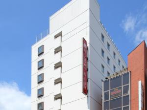 
a tall building with a clock on the side of it at Hotel Pearl City Morioka in Morioka
