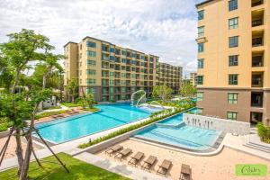 uma imagem de uma piscina num complexo de apartamentos em The Rain Cha-am Huahin By Thanon em Cha Am