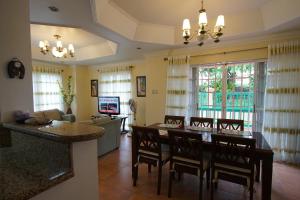 a kitchen and living room with a table and chairs at Charming Tagaytay Vacation Home in Tagaytay