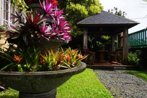 un jardín con una plantadora de piedra y un cenador en Charming Tagaytay Vacation Home en Tagaytay