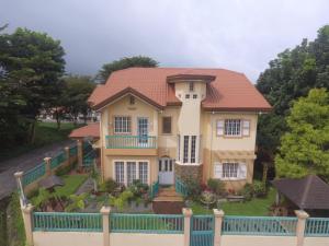 une grande maison avec une clôture devant elle dans l'établissement Charming Tagaytay Vacation Home, à Tagaytay