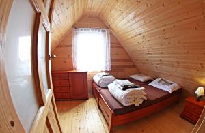a room with a bed in a wooden cabin at Domki Letniskowe Amelia in Ustronie Morskie