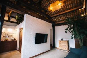 a living room with a tv on a white brick wall at The Orchid Hotel - Old Town & Drum Tower in Beijing