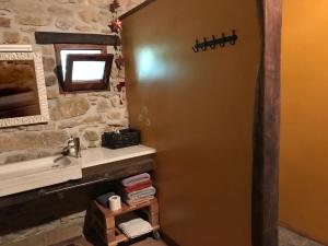 a bathroom with a door with a sink and a mirror at Mas Ombravella in Mieras