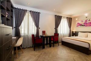 a hotel room with a bed and a table and chairs at Vien Dong Hotel 2 in Ho Chi Minh City +41 photos