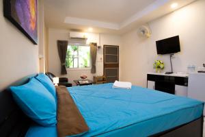 a bedroom with a blue bed and a desk at Siam@Sea Resort in Na Jomtien