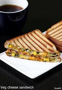 a sandwich and some french fries on a plate at Hotel Saffron Inn in New Delhi