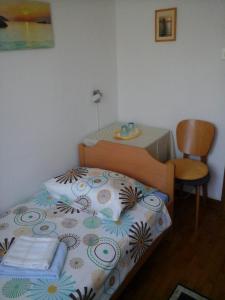 a bedroom with a bed and a table and a chair at Guesthouse Leasol in Lucija