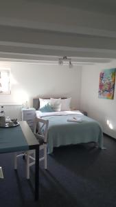 a white bedroom with a bed and a desk at em Dorfkrug in Euskirchen