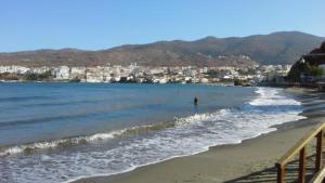 a view of a beach with a city in the background at Vassiliki Studios in Andros