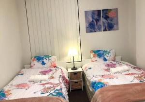 a bedroom with two beds and a lamp at Shine Apartment in Liverpool