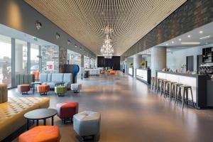 a lobby with chairs and tables and a bar at a&o Hostel Venezia Mestre in Mestre