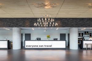 a lobby with a sign that says everyone can travel at a&o Hostel Venezia Mestre in Mestre