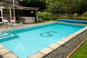 uma piscina com algil ao lado em Lake Karapiro Lodge em Tirau