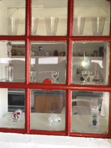 a red glass window with a bunch of glasses at Bulbrovejs Bed & Breakfast in Havdrup