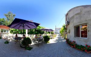 a group of people sitting at tables under umbrellas at Hotel Laguna in Eforie Nord