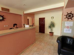 a woman sitting at a counter in a waiting room at Hotel Laguna in Eforie Nord