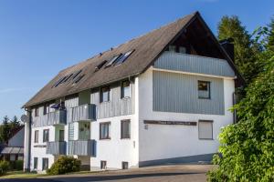 un grand bâtiment blanc avec un toit en gambrel dans l'établissement Ferienwohnung Haus am Durrberg "St. Hubertus", à Warmensteinach