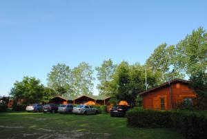 a group of cottages with cars parked in a lot at Jaskolcze Gniazdo in Dziwnówek