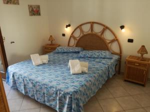 a bedroom with a large bed and two night stands at L'Agave in Ricadi