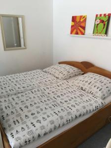 een bed met een wit dekbed in een slaapkamer bij Ferienwohnung Am Wald in Schönwald