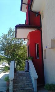un edificio rojo con escaleras que conducen a una puerta roja en Villa Sunny Hill, en Fish Fish