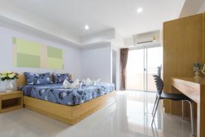 a bedroom with a bed and a large window at Jr Mansion On Nut Soi 25 in Bangkok