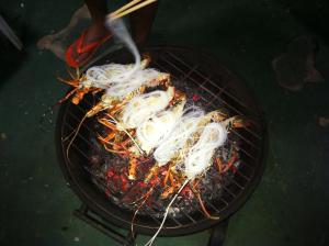 a bunch of food cooking on a grill at Mangroven River View Hotel in Bentota